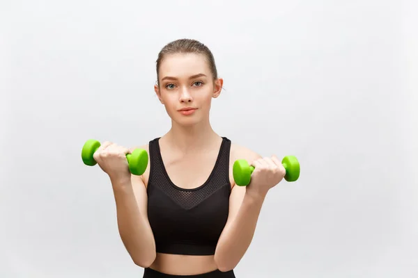 Mulher fitness feliz levantando halteres sorrindo alegre, fresco e enérgico. Caucasiano fitness girl treinamento isolado no fundo branco . — Fotografia de Stock