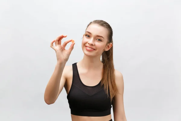 Suplementos, Esportes, Vitaminas, Dieta, Nutrição, Alimentação saudável, Estilo de vida. Close up de mulher fitness sorrindo tomar pílula com óleo de fígado de bacalhau Omega-3, vitamina D, E, A cápsulas de óleo de peixe — Fotografia de Stock