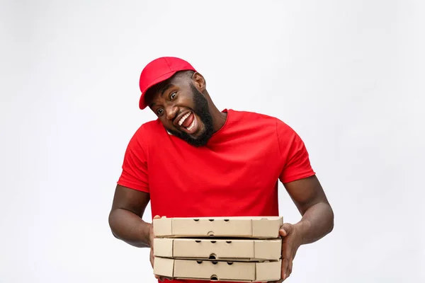 Concept de livraison : Beau livreur de pizza africaine parlant au mobile avec une expression faciale choquante. Isolé sur fond gris. — Photo