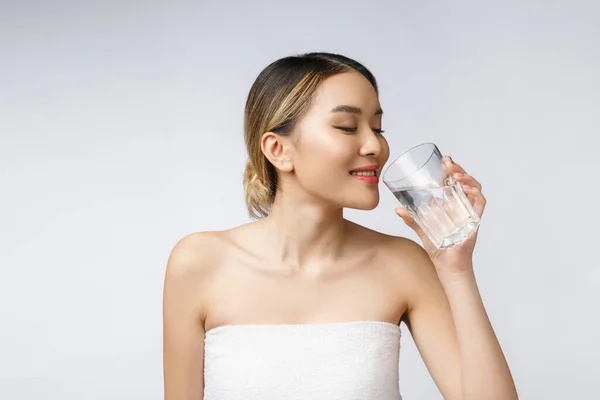 Wanita muda tersenyum santai minum air bersih. — Stok Foto