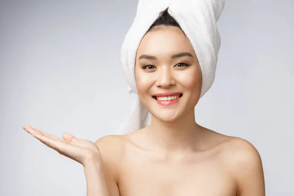 Porträtt vacker asiatisk kvinna wow förvånad och pekar handen till höger på grå bakgrund, känslor åtgärder, visar din produkt eller budskap — Stockfoto