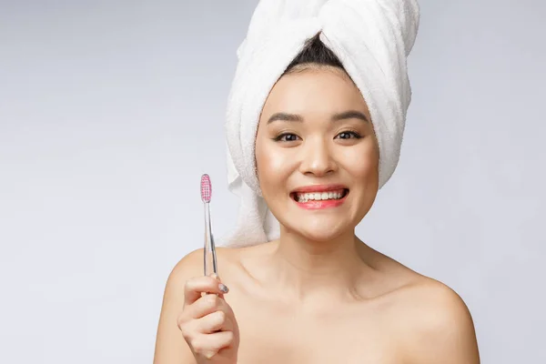 Чудова молода жінка на білому ізольованому фоні тримає зубну щітку (Азія). — стокове фото