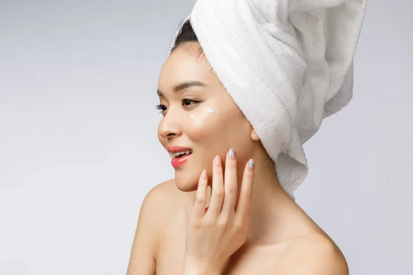 Concetto di salute e bellezza - Attraente donna asiatica che applica la crema sulla sua pelle, isolata sul bianco. — Foto Stock