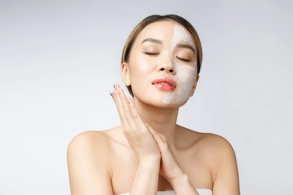 Charming pleasant woman applying cream on half face. — Stock Photo, Image