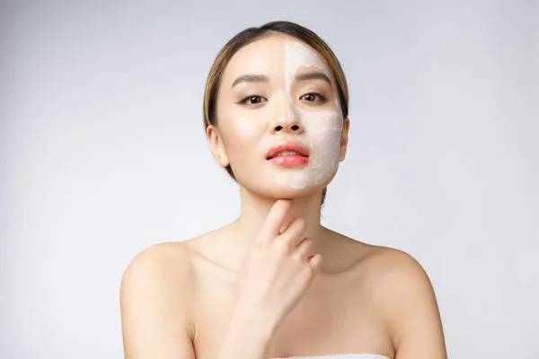 Charming pleasant woman applying cream on half face. — Stock Photo, Image