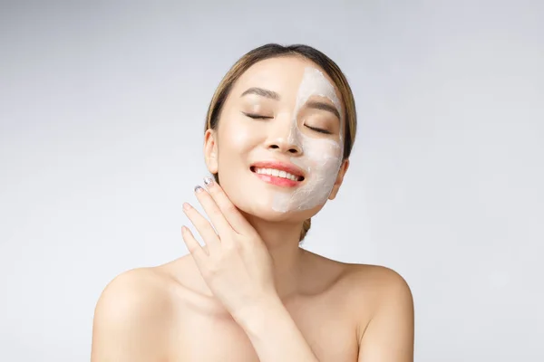 Okouzlující příjemná žena nanášení krému na polovinu obličeje. — Stock fotografie