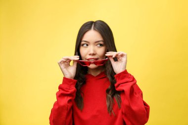 Renkli arka planda kırmızı güneş gözlüklü oldukça mutlu bir kadın.