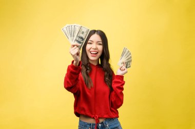 Genç ve güzel bir kadının yakın plan fotoğrafı. Para elimizin altında. Sarı arka plan, fotokopi alanı.