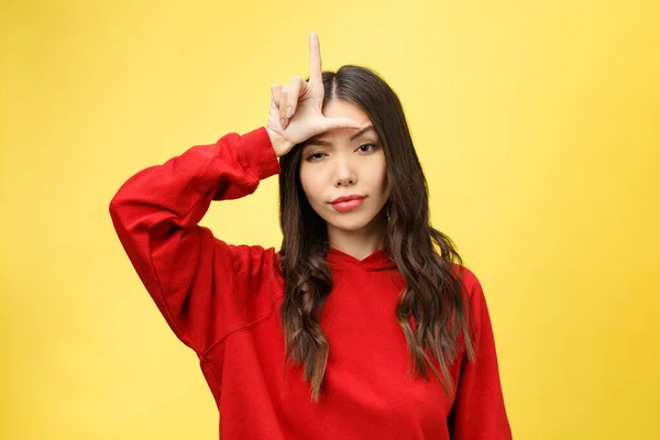 Uma jovem bonita a mostrar sinal telefónico com os dedos. Retrato de estúdio colorido com fundo amarelo . — Fotografia de Stock