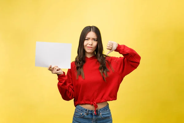 Jeune femme adulte tenant feuille de papier vierge sur fond isolé stressé, choqué par la honte et le visage surprise, en colère et frustré. Peur et contrariété — Photo