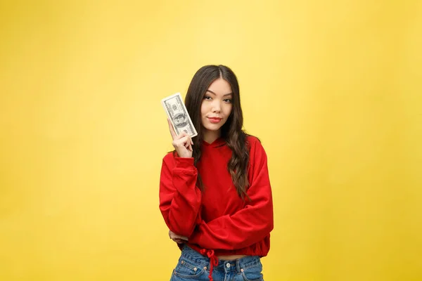 Closeup of young beautiful woman with us dollar money in hand over yellow background, with copy space — Stock Photo, Image