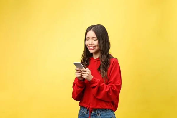 Glada ung kvinna talar på mobiltelefon isolerad på gul bakgrund — Stockfoto