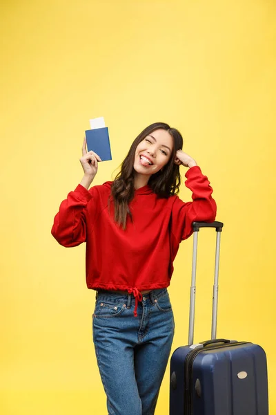 Cestování žen. Mladá krásná asijská žena cestovatel s kufrem a cestovním pasem na žlutém pozadí — Stock fotografie