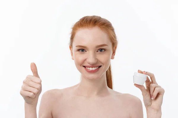 Retrato de mulher bonita sorrindo enquanto toma algum creme facial isolado no fundo branco com espaço de cópia . — Fotografia de Stock