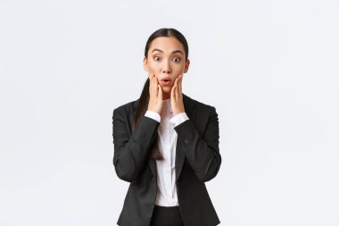 Şaşırmış ve şaşırmış Asyalı kadın iş kadını büyük haberleri duyuyor. Satıcı kadın şok edici haberler alıyor, takım elbise içinde kameraya bakıyor, iş ortaklarıyla büyük bir anlaşma imzalıyor.