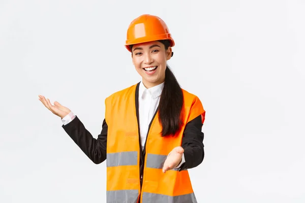 Sonriendo exitosa mujer asiática gerente de construcción, arquitecto presentar su proyecto, señalando de la mano en el plano, explicar su plan de construcción. Mujer industrial dando discurso a los inversores — Foto de Stock