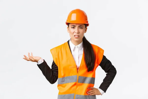 Então, o que se passa? Frustrado e desapontado asiático mulher engenheiro chefe reclamando em empregados, repreendendo alguém, usar casaco reflexivo e capacete de segurança, levantando a mão confuso — Fotografia de Stock
