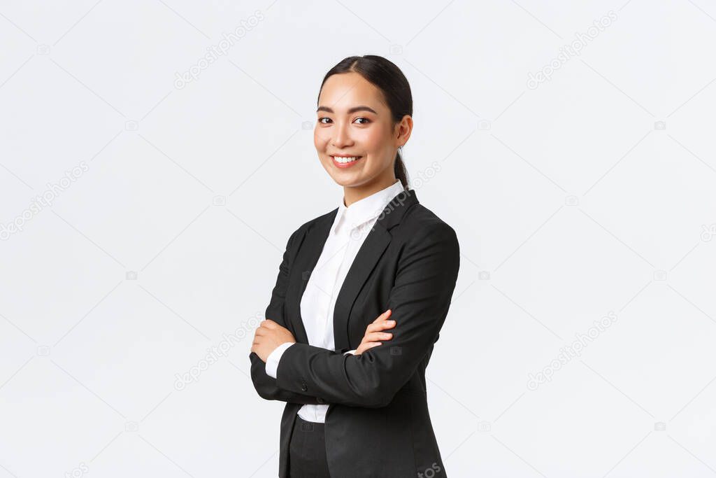 Professional young asian female entrepreneur, real eastate agent in suit cross arms and looking confident at camera. Successful businesswoman leading business. Team lead starting meeting