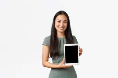 Gülümseyen neşeli Asyalı kadın çevrimiçi olarak kendi moda dükkanını açıyor, memnun ve gururlu ifadesiyle dijital tablet ekranını gösteriyor, uygulamayı tanıtıyor, tıklama linki öneriyor, beyaz arkaplan