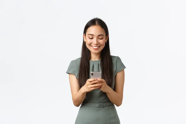 Small business owners, women entrepreneurs concept. Smiling young female running startup in internet, checking messages from clients, texting someone on mobile phone, using smartphone — Stock Photo, Image