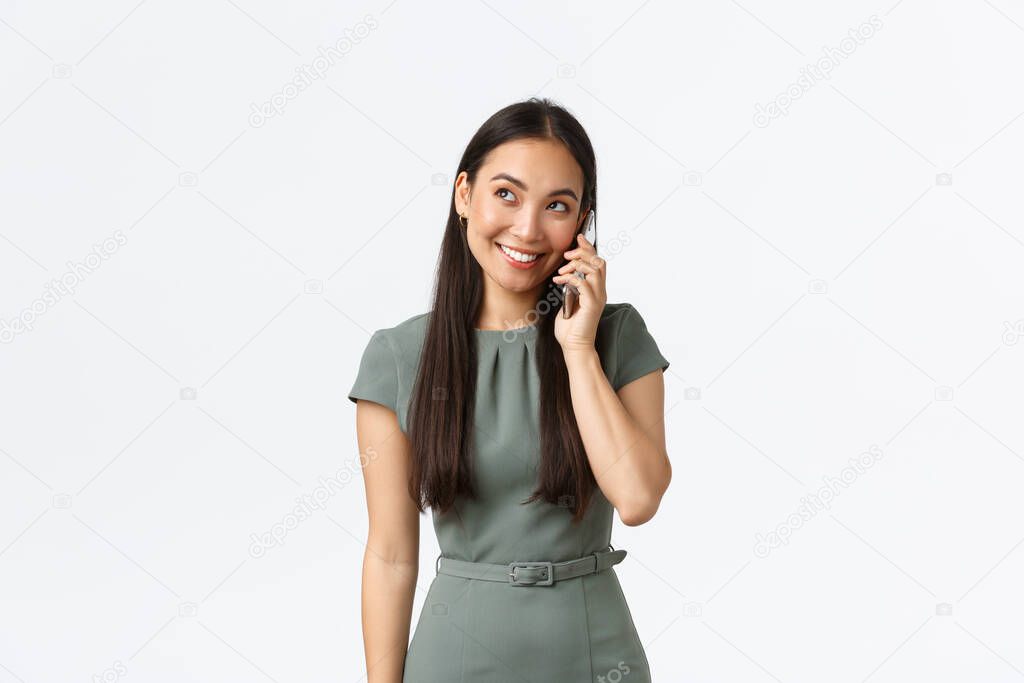 Small business owners, women entrepreneurs concept. Smiling friendly-looking pretty asian businesswoman having phone conversation with customer, confirm order, talking on smartphone