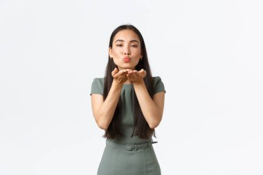 Küçük işletme sahipleri, kadın girişimciler konsepti. Kadın çekici Asyalı kadın şık giyinmiş, kameraya mwah üflüyor, sana hava öpücüğü yolluyor, beyaz arka planda duruyor.