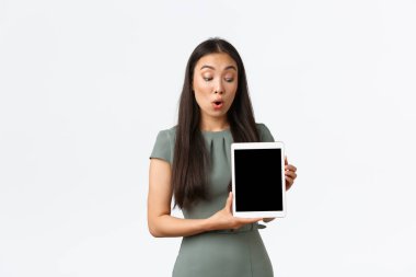 Küçük işletme sahipleri, ev kavramından başlayarak ve çalışarak. Şaşırmış ve etkilenmiş Asyalı kadın dijital tablet ekranına bakıyor. Şaşırtıcı bir ifadeyle, stoktaki yeni nesneleri kontrol ediyor.