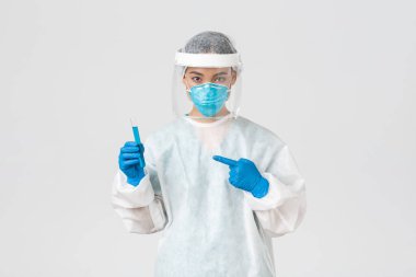 Covid-19, koronavirüs hastalığı, sağlık çalışanları konsepti. Ciddi bir kendinden emin Asyalı kadın araştırmacının portresi, test tüpünde aşı tutan kişisel koruyucu ekipman laboratuvar çalışanı