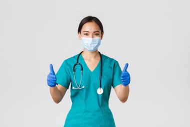 Covid-19, koronavirüs hastalığı, sağlık çalışanları konsepti. Kendine güvenen profesyonel doktor, Asyalı doktor, kişisel koruyucu ekipman, hastaya garanti ve güvence, tıbbi maske takın.