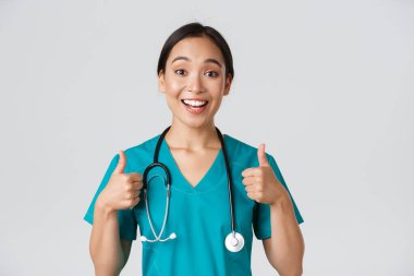 Sağlık çalışanları, virüsü önleme, karantina kampanyası konsepti. Genç ve destekleyici Asyalı hemşire onayladı. Doktor neşelen, birini cesaretlendir ya da iltifat et.