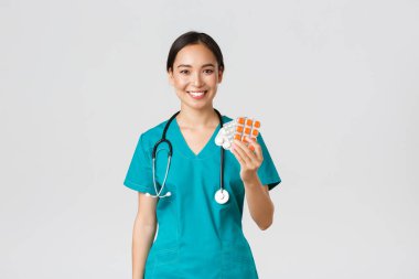 Sağlık çalışanları, virüsü önleme, karantina kampanyası konsepti. Dost canlısı bayan Asyalı hemşire, doktor hasta ilaç reçetesini açıkla, uyuşturucu gösteriyor ve gülümsüyor, beyaz arkaplan