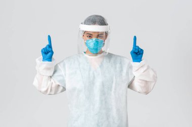Covid-19, koronavirüs hastalığı, sağlık çalışanları konsepti. Ciddi görünümlü genç Asyalı kadın doktor, solunum cihazında teknoloji laboratuarı çalışanı ve kişisel koruyucu ekipman, beyaz arka plan