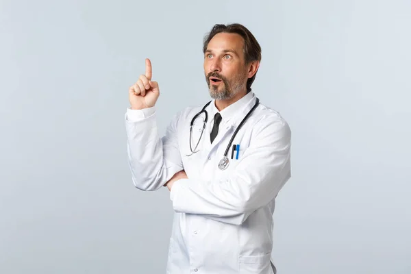 Covid-19, ξέσπασμα του ιού της στέψης, επαγγελματίες υγείας και πανδημία. Ενθουσιασμένος γιατρός με λευκό παλτό έκανε αποκάλυψη, σηκώστε δείκτη σε χειρονομία eureka, έχουν εξαιρετική ιδέα — Φωτογραφία Αρχείου