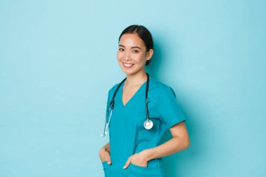 Covid-19, sosyal uzaklık ve koronavirüs salgını konsepti. Profesyonel özgüvenli, güzel Asyalı kadın doktor, steteskoplu hemşire geniş bir gülümsemeyle kliniğe hoş geldiniz.