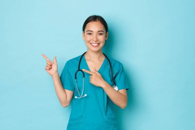 Covid-19, sosyal uzaklık ve koronavirüs salgını konsepti. Profesyonel doktor, kadın hemşire ya da doktor hastaları bilgilendirir. Sol üst köşeyi işaret ederek klinik afişini gösterir.