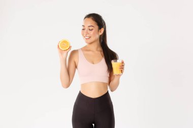 Spor, refah ve aktif yaşam tarzı konsepti. Sağlıklı ve ince Asyalı kız tavsiyelerinin portresi kahvaltıda sağlıklı yiyecekler yemek, egzersiz için enerji kazanmak, taze meyve suyu ve portakal suyu içmek.