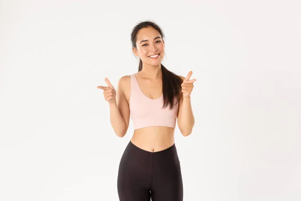 Esporte, bem-estar e conceito de estilo de vida ativo. alegre sorrindo bonito asiático fitness menina, treinador de ginásio ou esportista parabenizá-lo, apontando os dedos para a câmera, louvor bom treino, fundo branco — Fotografia de Stock