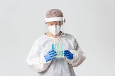Tıp çalışanları, covid-19 salgını, koronavirüs konsepti. Laboratuvar teknisyeni, bilim adamı ya da doktor portresi. Aşı örnekleriyle test tüpleri tutuyor, tedavi arıyor.