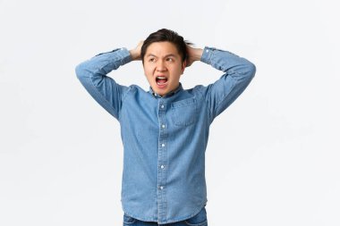 Sorunlu ve endişeli Asyalı adam panikliyor, büyük bir sorunu var, korkunç bir durumla karşı karşıya, elini tutuyor kararsız ve hayal kırıklığına uğramış, başka tarafa bakıyor, ne yapıyor bilmiyorum, beyaz arka plan