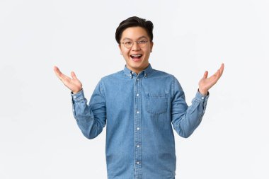 Tel takan, gözlüklü, gülümseyen, dostça gülümseyen ve elini kaldıran mutlu Asyalı adam heyecanlı, iyi haberler alan, birini sevindiren ya da öven, beyaz arka planda duran