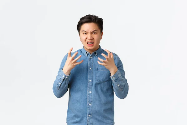 Outraged aggressive and pissed-off asian man shaking hands frustrated and mad, frowning and grimacing, swearing angry at someone, feeling furious, standing white background — Stockfoto