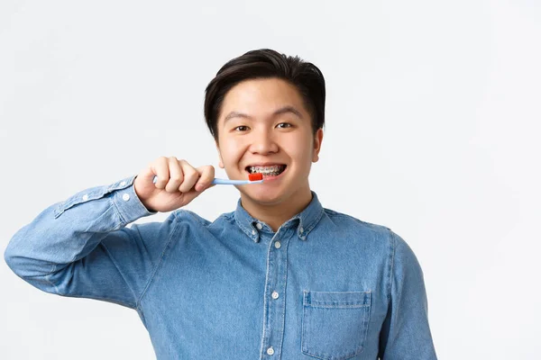 Dental care man brushing teeth with braces