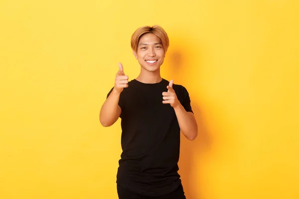 Portrét drzého usměvavého Asiata, který vypadá spokojeně a ukazuje prstem na kameru, něco chválí nebo dělá kompliment — Stock fotografie