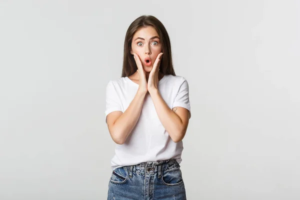 Portrait of surprised and amused brunette girl looking wondered, gasping impressed — Stock Photo, Image