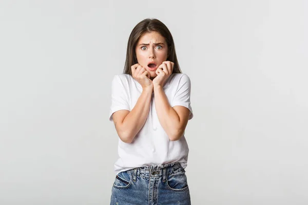 Portrait of scared and horrified young woman gasping and looking frightened — Stock Photo, Image