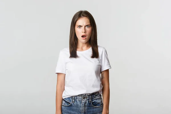 Porträtt av förskräckt och chockad ung kvinna kippar och rynkar pannan frustrerad, ser förolämpad — Stockfoto