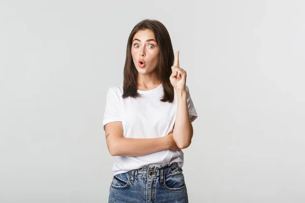 Portrait of excited girl raising finger, have suggestion or thought — Stock Photo, Image