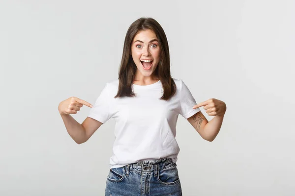 Emocionado chica morena feliz sonriendo, señalando los dedos en el logotipo, mostrando pancarta — Foto de Stock