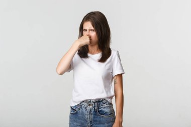 İğrenç kadın burnunu kapattı ve kötü kokudan rahatsız oldu.