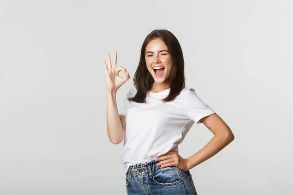 Confiado y optimista chica atractiva mostrando gesto de pulgar hacia arriba en la aprobación — Foto de Stock